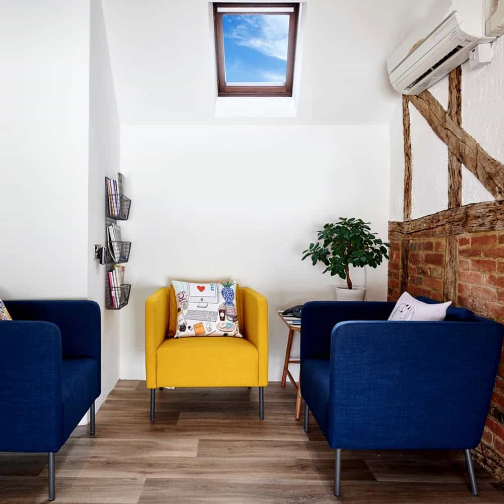 Modern seating area with skylight and colourful armchairs