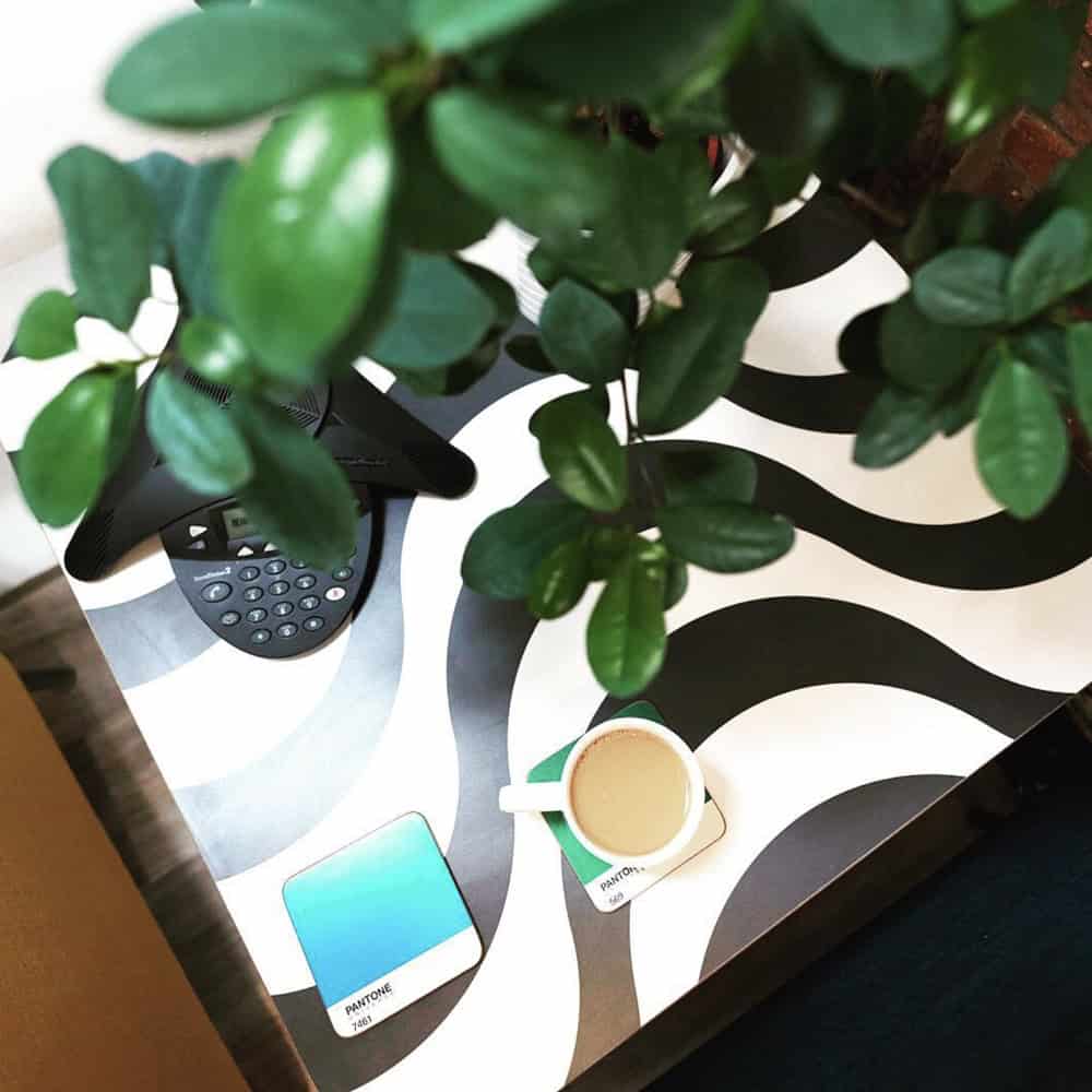 Overhead view of desk with plant, tea and phone